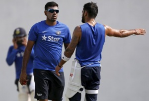 Virat Kohli speaks with his teammate Ravichandran Ashwin during a practice session 